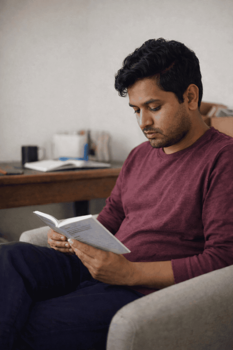 adult learning to read at home while holding a book