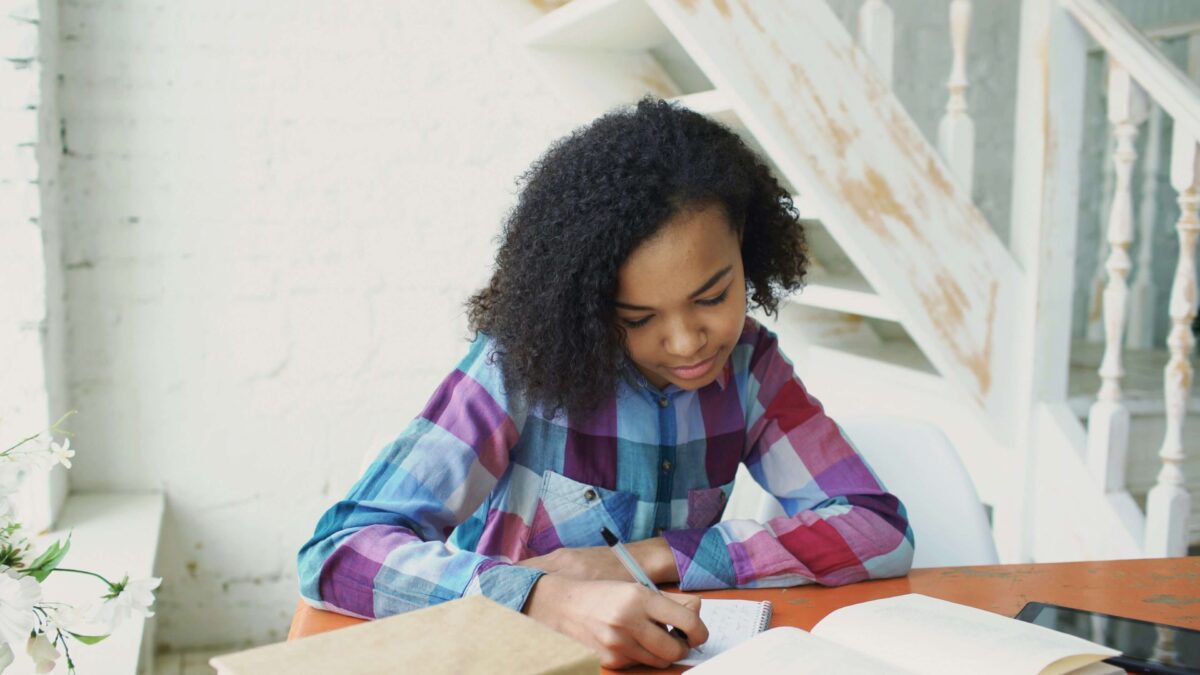 teenager improving reading skills while studying at a desk